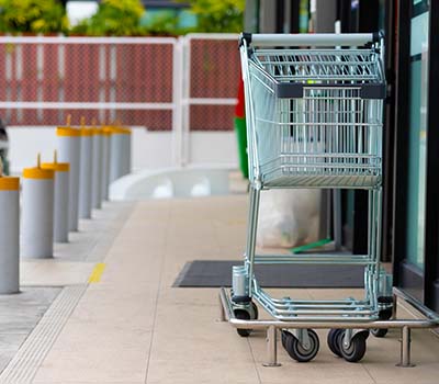 Image of a bollard installed between a parking lot and store entrance